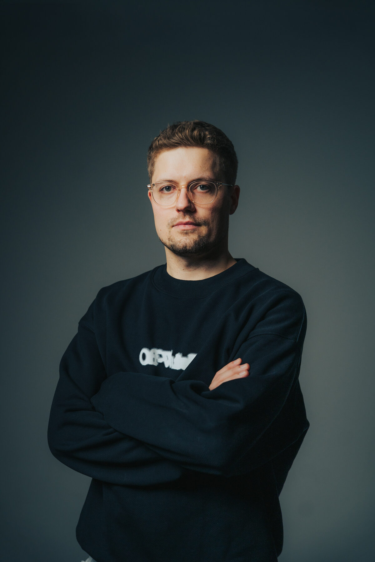 Portrait von It's MA mit Kopfhörern, Studioaufnahme mit orangem Hintergrundlicht